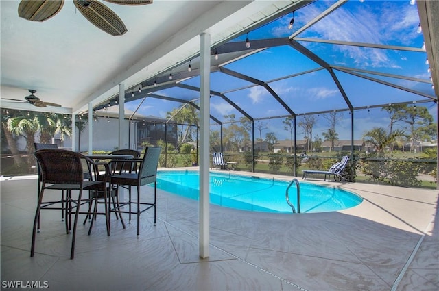 view of pool featuring a patio, ceiling fan, and glass enclosure