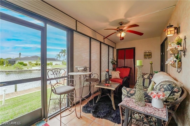 sunroom / solarium with a water view and ceiling fan