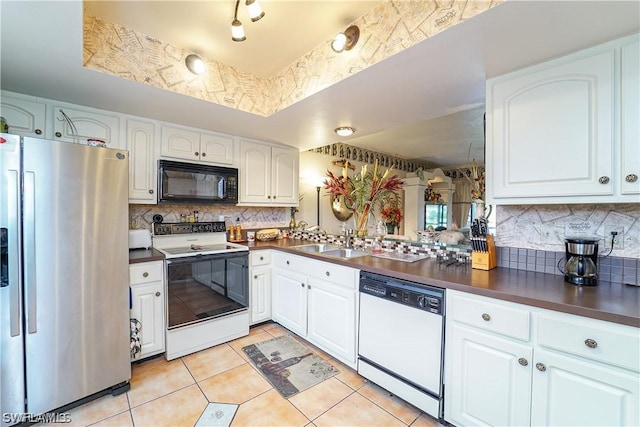 kitchen featuring white appliances, sink, decorative backsplash, light tile patterned flooring, and white cabinetry