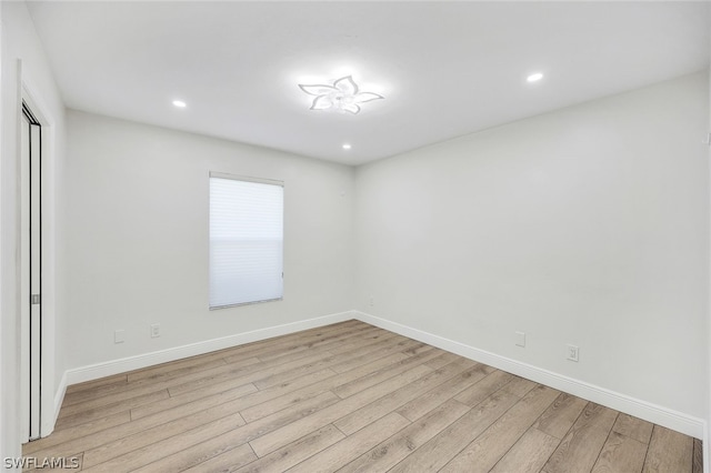 empty room featuring recessed lighting, wood finished floors, and baseboards