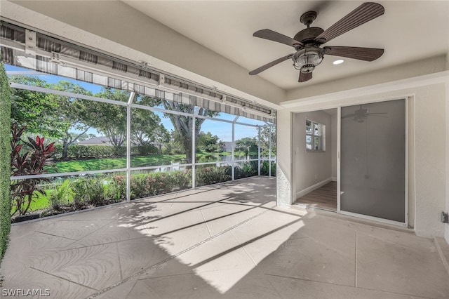 unfurnished sunroom featuring ceiling fan