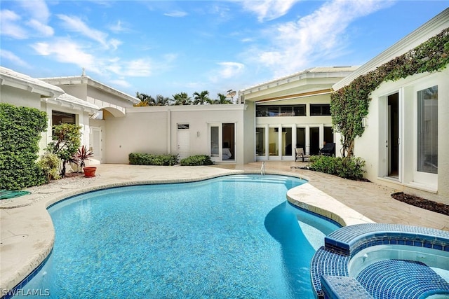 view of swimming pool with an in ground hot tub and a patio