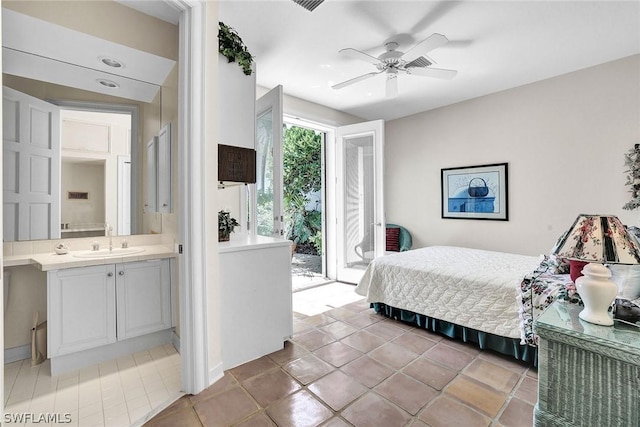 tiled bedroom with ceiling fan, access to exterior, ensuite bathroom, and sink