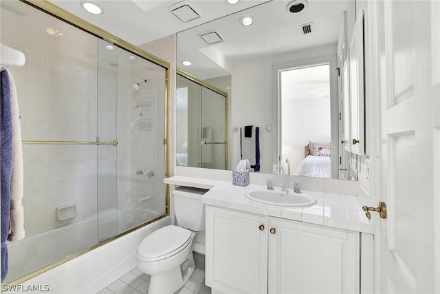 full bathroom with toilet, vanity, tile patterned floors, and bath / shower combo with glass door