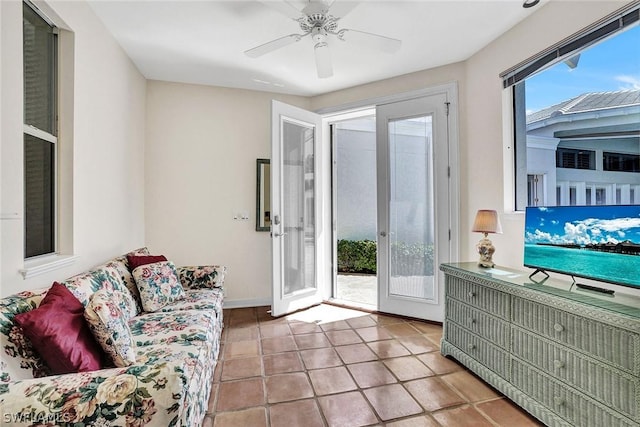 tiled living room with french doors and ceiling fan