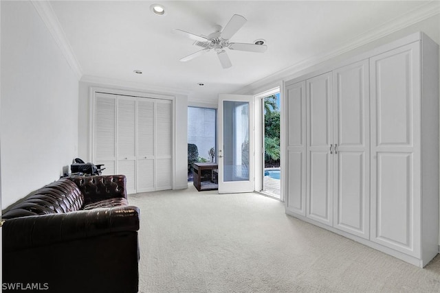 sitting room with light colored carpet, ceiling fan, and crown molding