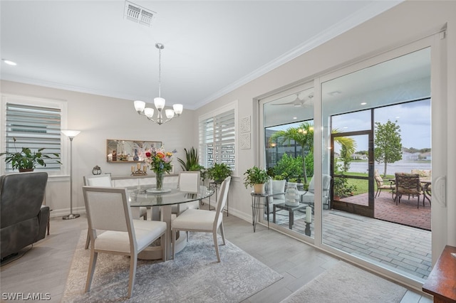 dining space featuring ceiling fan with notable chandelier, light wood-type flooring, and ornamental molding