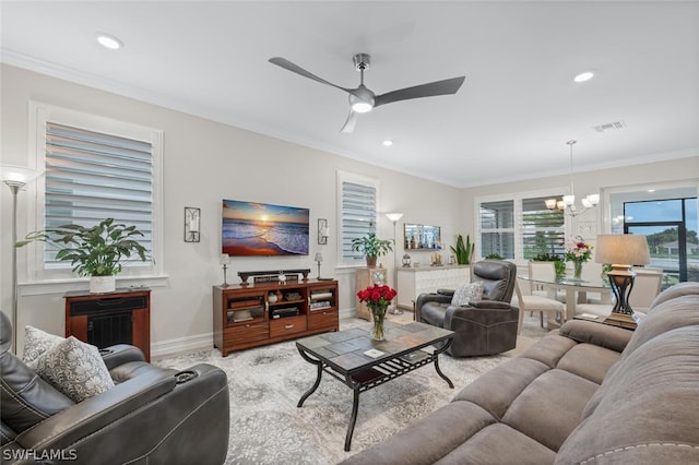 living room featuring ceiling fan with notable chandelier and ornamental molding