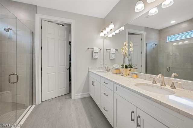 bathroom featuring walk in shower, wood-type flooring, and vanity