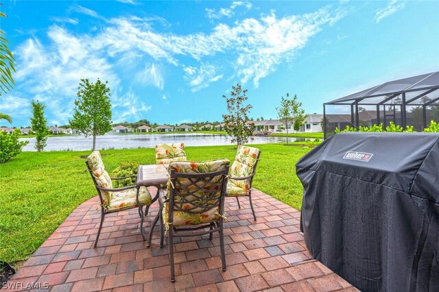 view of patio featuring a lanai, grilling area, and a water view