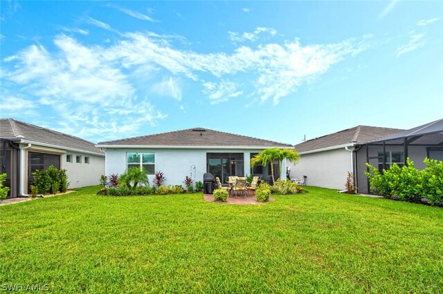 back of property with a lanai, a lawn, and a patio area