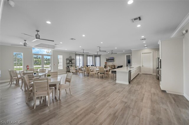 dining area with ornamental molding, ceiling fan, and light hardwood / wood-style floors