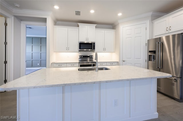 kitchen with a kitchen island with sink, white cabinets, and appliances with stainless steel finishes