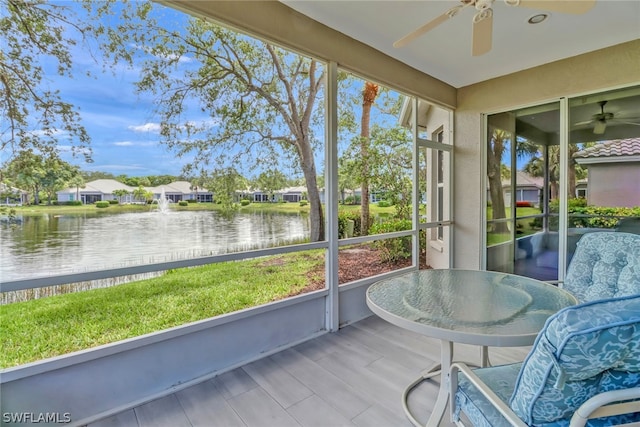 unfurnished sunroom with a water view and ceiling fan