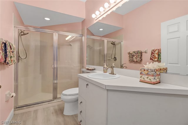 bathroom with hardwood / wood-style floors, toilet, an enclosed shower, and vanity