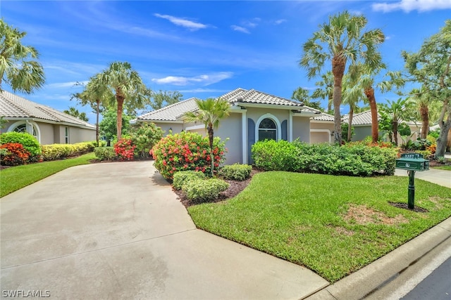 mediterranean / spanish-style home with a garage and a front lawn