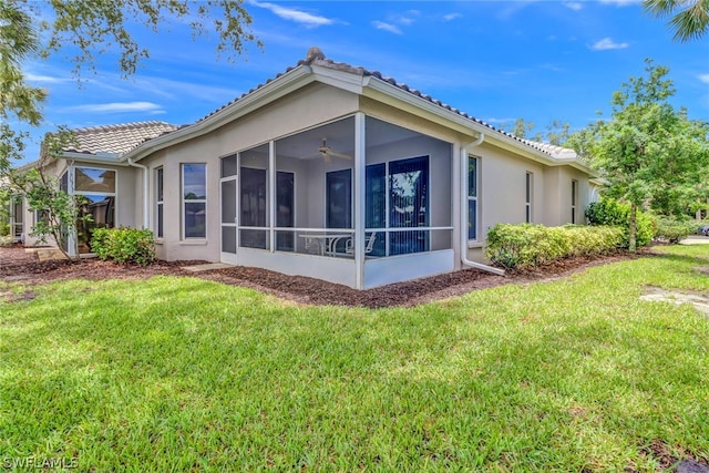 back of property featuring a sunroom and a yard