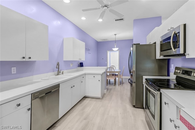 kitchen with white cabinetry, sink, stainless steel appliances, kitchen peninsula, and pendant lighting