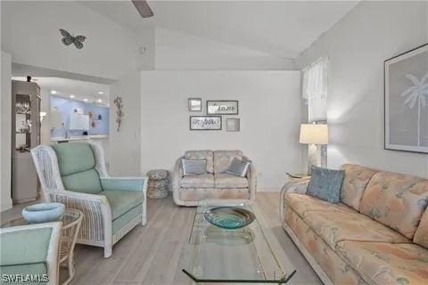 living room featuring light hardwood / wood-style flooring and vaulted ceiling