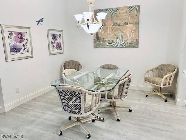 dining space featuring hardwood / wood-style flooring and a chandelier