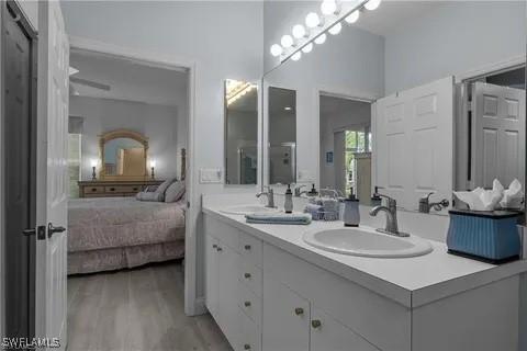 3357 Wildwood Lake Cir, Bonita Springs, FL 34134 - full bathroom with a sink, ensuite bathroom, double vanity, and wood finished floors