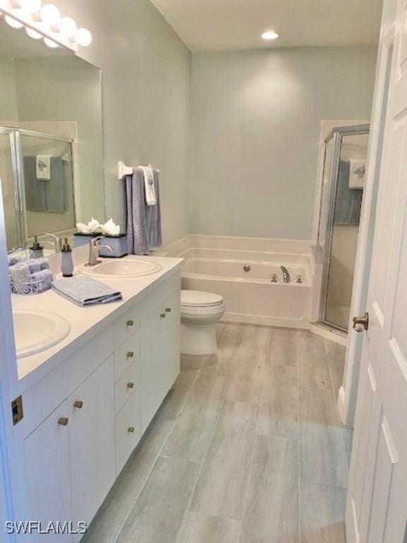 full bathroom with vanity, separate shower and tub, and toilet