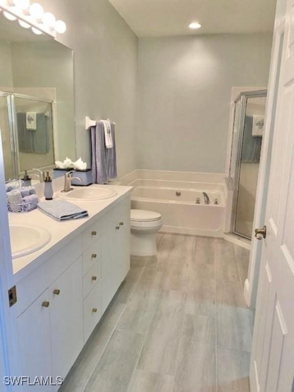 3357 Wildwood Lake Cir, Bonita Springs, FL 34134 - bathroom featuring a sink, double vanity, recessed lighting, a stall shower, and a garden tub