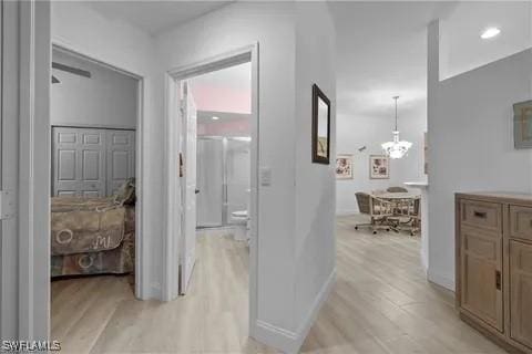 hall with a chandelier and light hardwood / wood-style floors