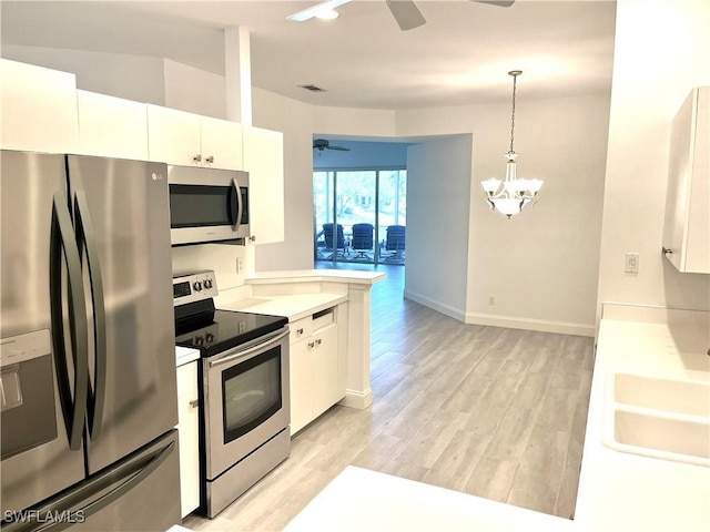 3357 Wildwood Lake Cir, Bonita Springs, FL 34134 - kitchen with ceiling fan with notable chandelier, a sink, white cabinetry, and appliances with stainless steel finishes