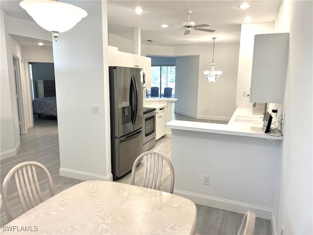 3357 Wildwood Lake Cir, Bonita Springs, FL 34134 - kitchen with stainless steel appliances, light wood-type flooring, baseboards, and ceiling fan with notable chandelier