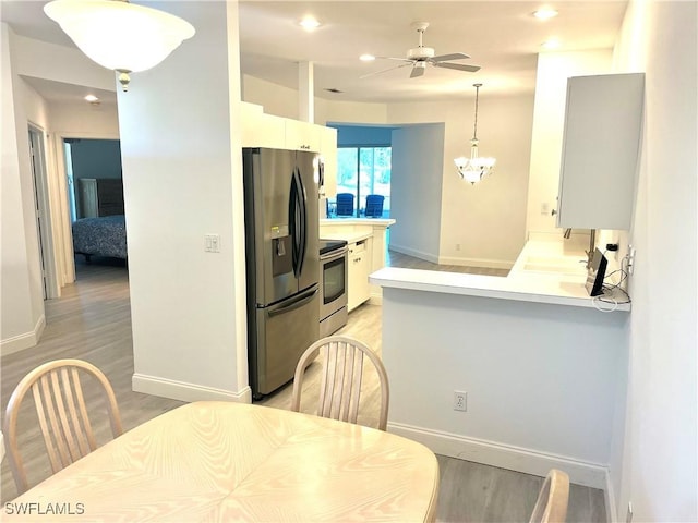 3357 Wildwood Lake Cir, Bonita Springs, FL 34134 - kitchen featuring light wood-style flooring, appliances with stainless steel finishes, ceiling fan with notable chandelier, and baseboards