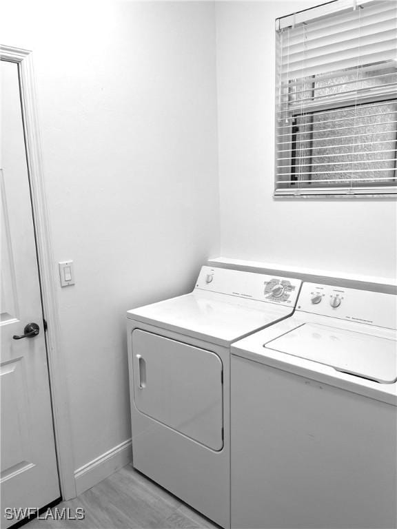3357 Wildwood Lake Cir, Bonita Springs, FL 34134 - washroom featuring baseboards, light wood-style floors, washing machine and dryer, and laundry area