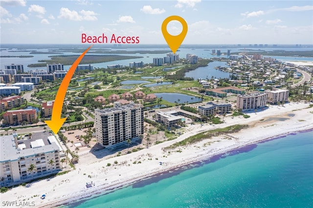 birds eye view of property featuring a beach view and a water view