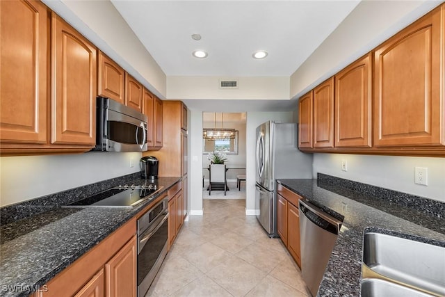 kitchen featuring light tile patterned floors, dark stone counters, sink, and stainless steel appliances