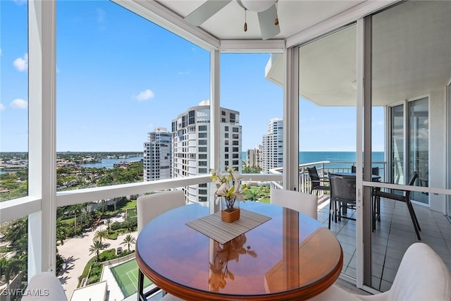 balcony featuring a water view and ceiling fan