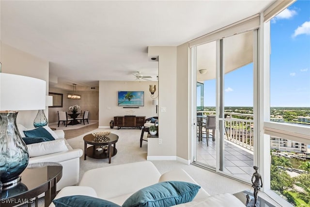 carpeted living room with ceiling fan and a wall of windows