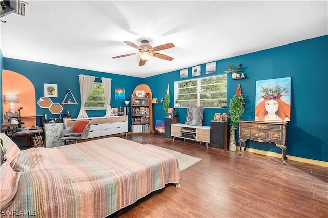 bedroom with ceiling fan, hardwood / wood-style floors, and multiple windows