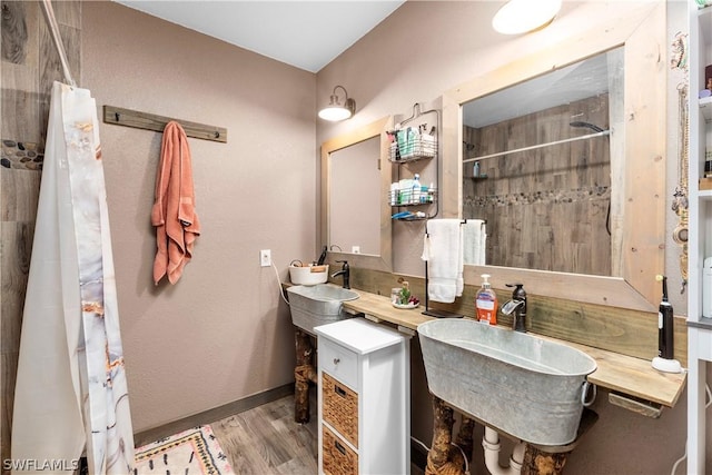 bathroom with wood-type flooring, sink, and a shower with shower curtain