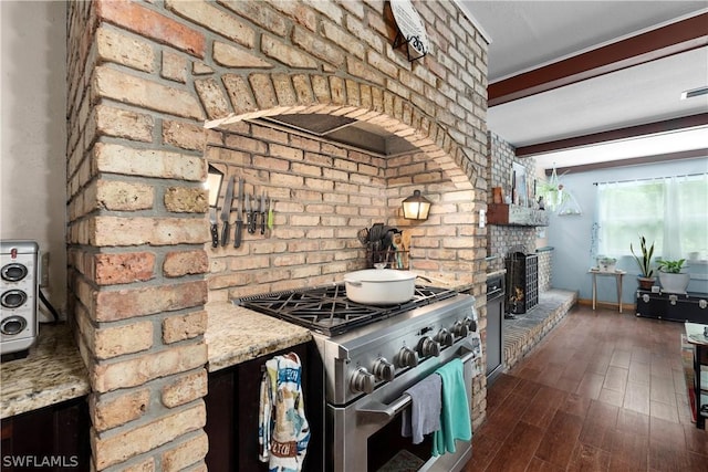 kitchen with dark hardwood / wood-style floors, a fireplace, high end stove, light stone counters, and beam ceiling