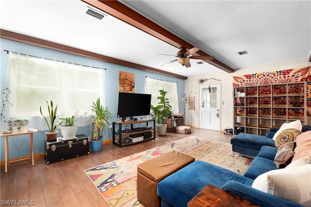 living room featuring ceiling fan, hardwood / wood-style flooring, a textured ceiling, and beamed ceiling