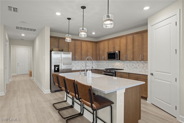 kitchen with visible vents, appliances with stainless steel finishes, decorative backsplash, and a sink