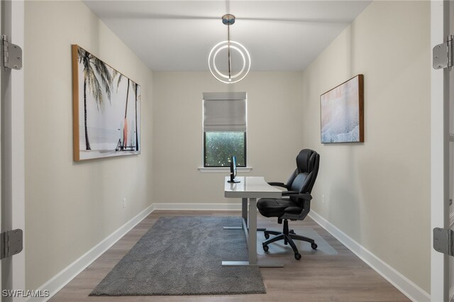 home office with baseboards and wood finished floors