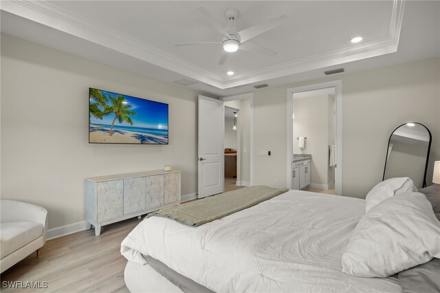 bedroom with baseboards, visible vents, a raised ceiling, ornamental molding, and light wood-style floors