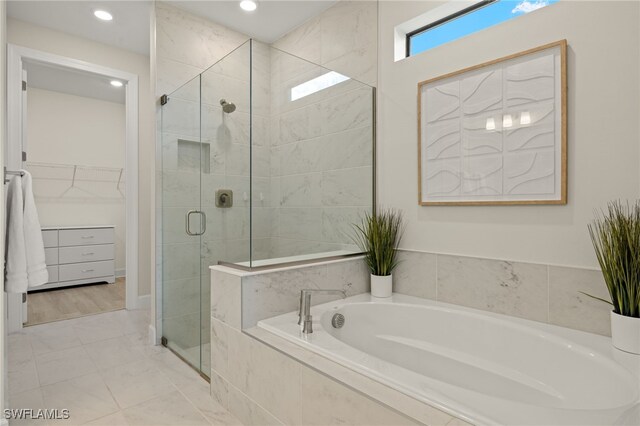 full bath featuring a stall shower, a walk in closet, recessed lighting, and a bath