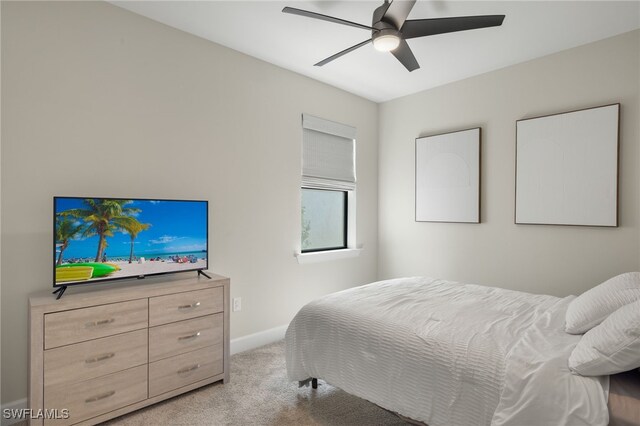 bedroom featuring light carpet, ceiling fan, and baseboards