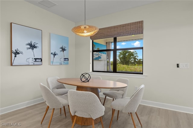 dining room featuring visible vents, baseboards, and wood finished floors