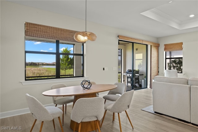 dining room featuring a wealth of natural light, baseboards, crown molding, and light wood finished floors