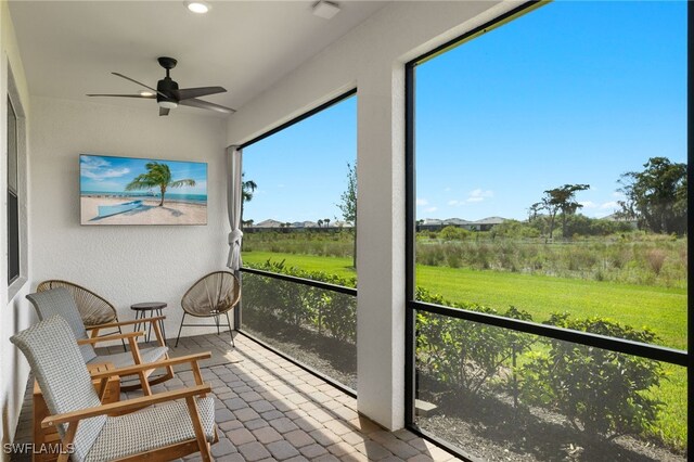 sunroom / solarium with a ceiling fan