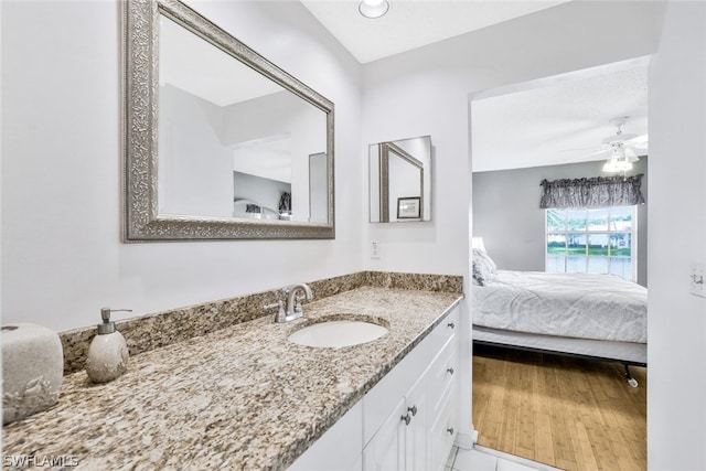 bathroom with tile patterned flooring, vanity, and ceiling fan