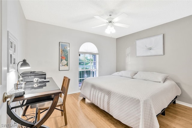 bedroom with ceiling fan, light hardwood / wood-style flooring, and a textured ceiling